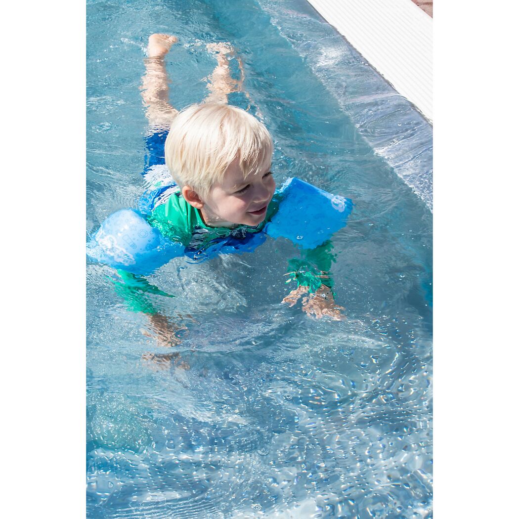 Kind mit Schwimmflügeln im Pool