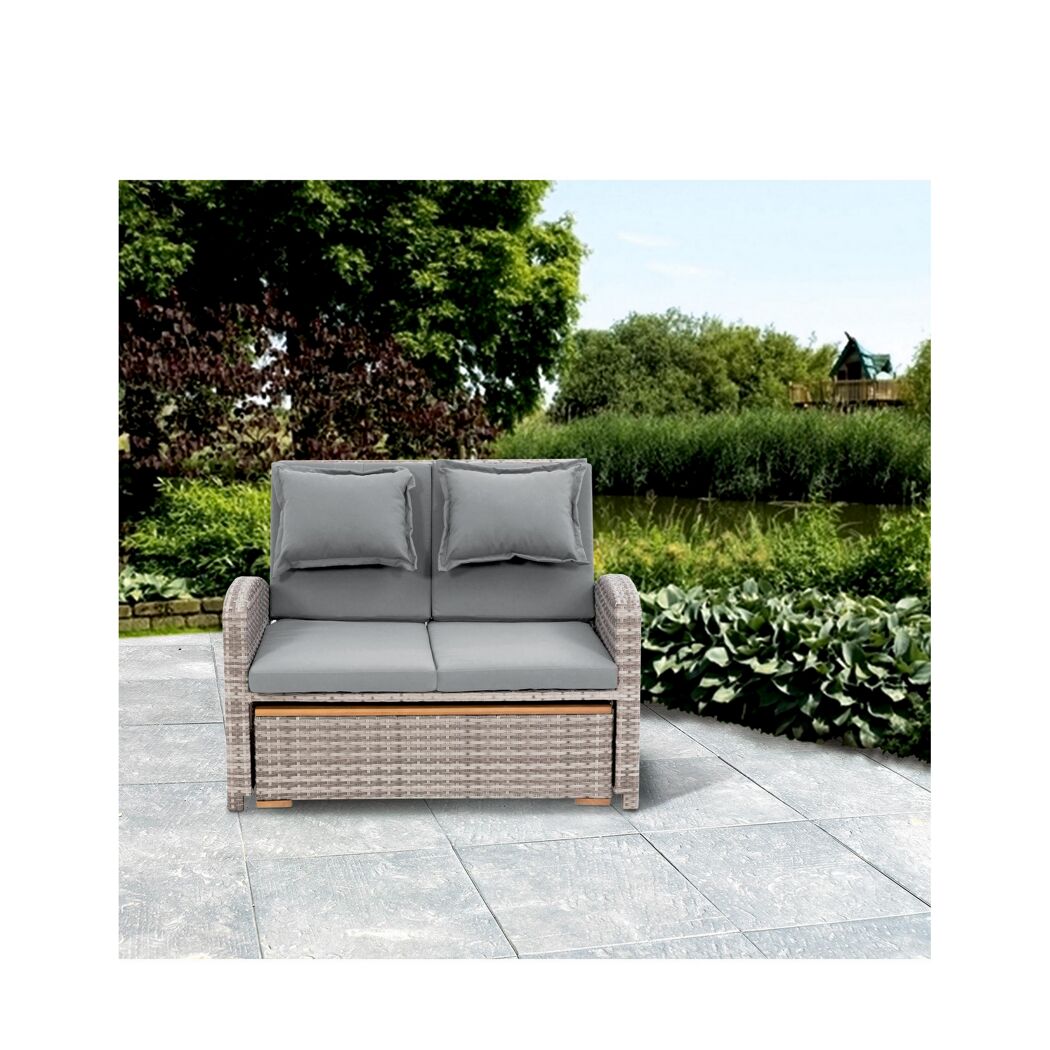 Graues Rattansofa mit zwei Kissen im Garten