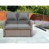 Graues Rattansofa mit zwei Kissen im Garten