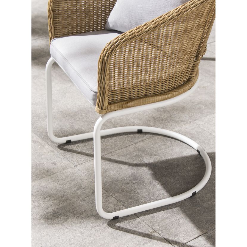 Rattan-Schaukelstuhl mit weißem Gestell und grauem Kissen