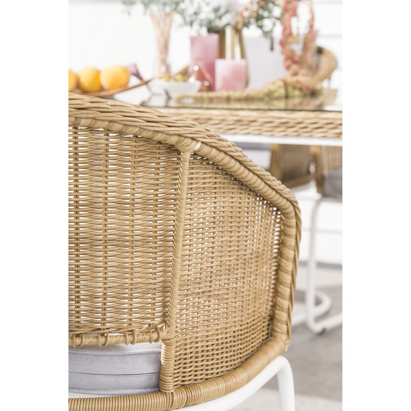 Rattan-Schaukelstuhl mit hellem Kissen
