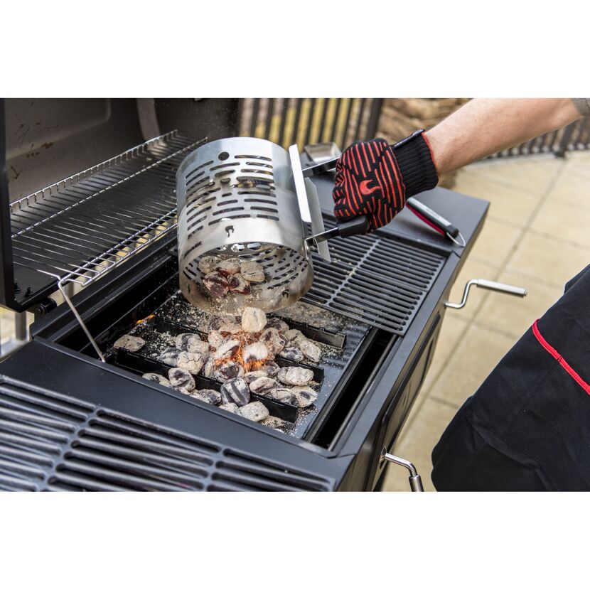Person verwendet einen Anzündkamin, um einen Grill zu starten.