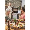 Drei Personen grillen und essen im Garten.