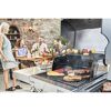 Personen grillen Steaks, Paprika und Gemüsespieße auf einem Gasgrill.