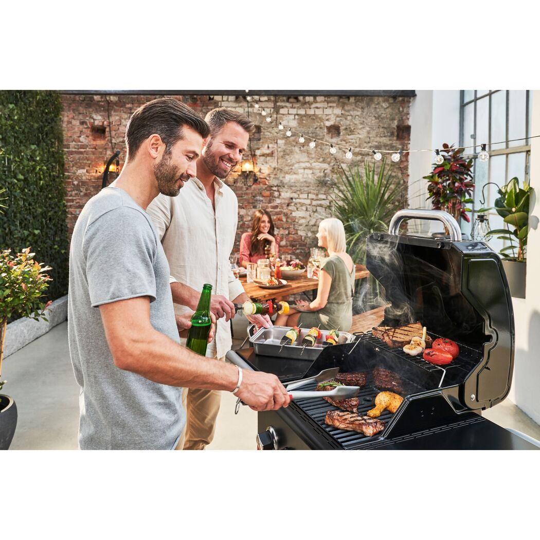 Personen grillen Fleisch und Gemüse auf einem Gas2Coal 2.0 Hybridgrill