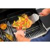 Person grillt Garnelen und Gemüse mit einem Spachtel