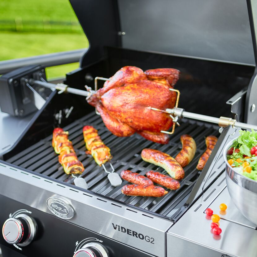 Hähnchen am Drehspieß, Würstchen und Gemüse-Spieße auf dem Grill