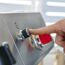 Person dreht einen Knopf am Gasgrill
