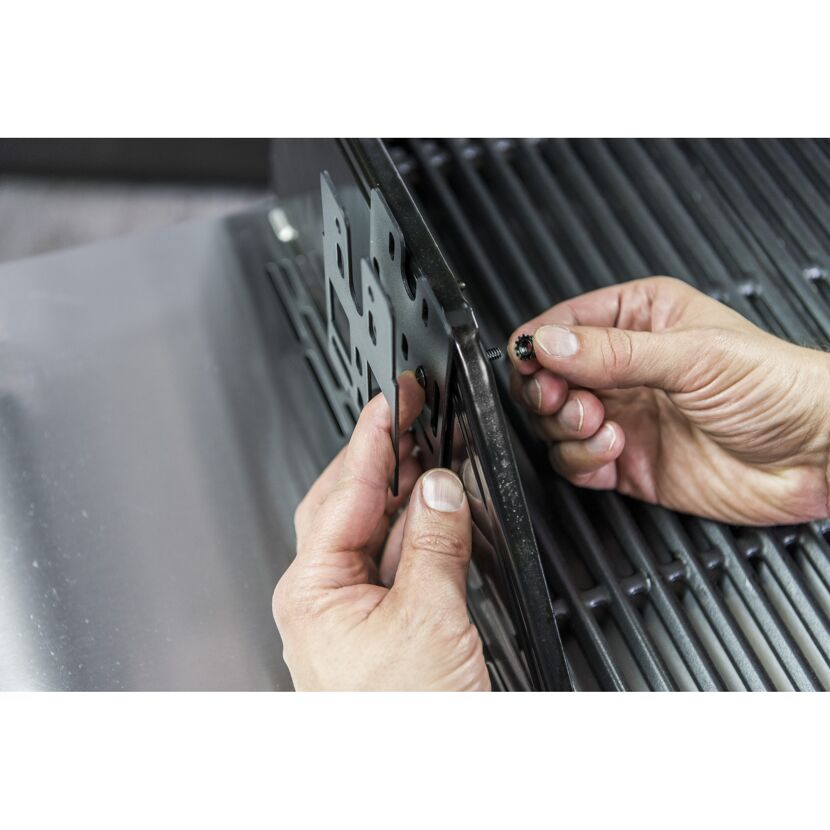 Person montiert einen Gasgrill.
