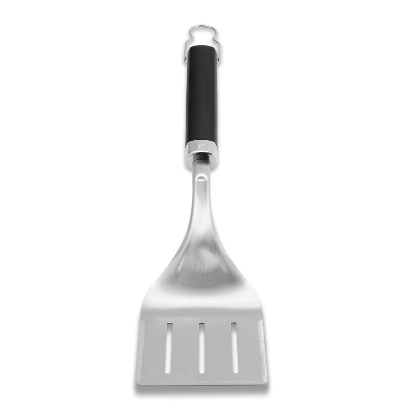 Grillwender mit schwarzem Griff und dreieckiger, silberner Fläche.