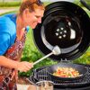 Person benutzt einen Woklöffel am Grill