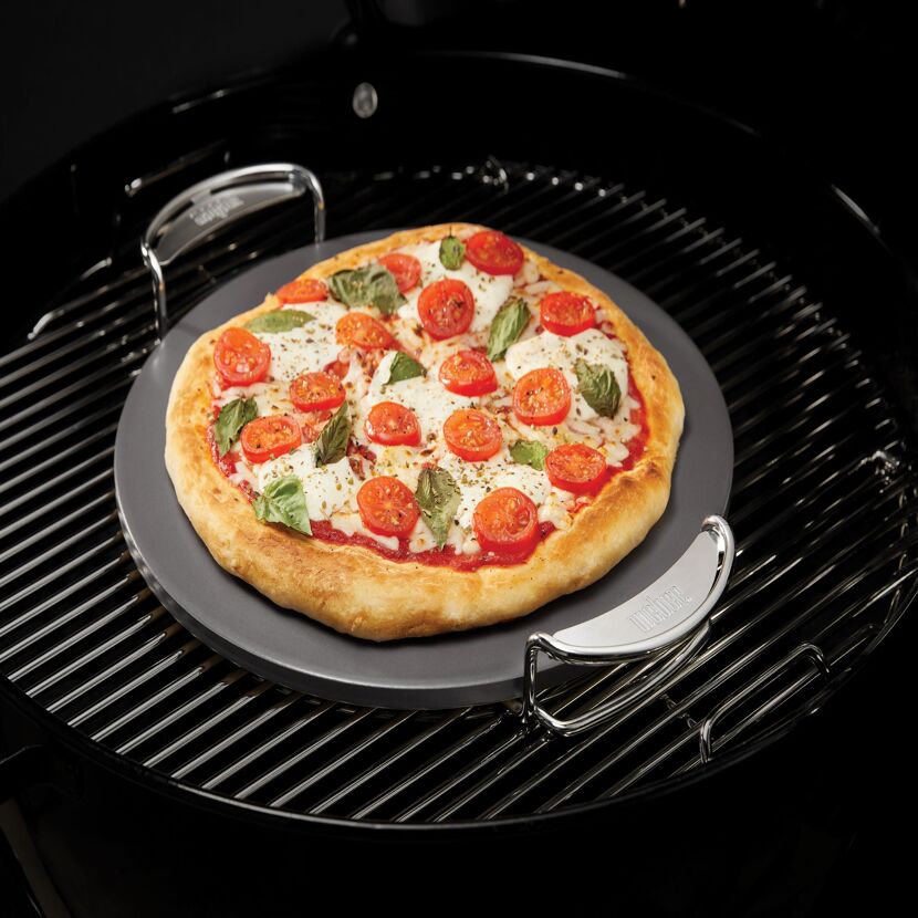 Pizza mit Mozzarella, Tomaten und Basilikum auf Pizzastein