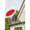 Roter Sonnenschirm und graue Loungeinsel auf einem Balkon