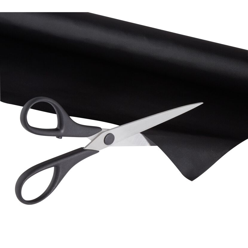 Schwarze Grillmatte wird mit Schere geschnitten
