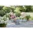 Person sitzt in einem Gartenmöbelset aus Polyrattan.