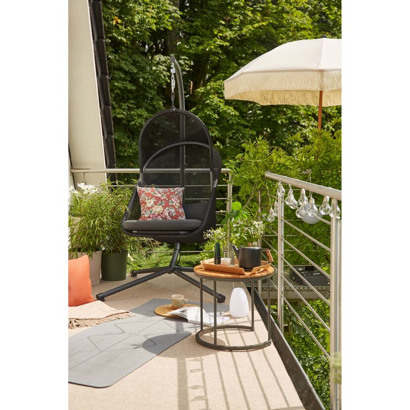 Hängesessel auf einem Balkon mit Sonnenschirm und Beistelltisch