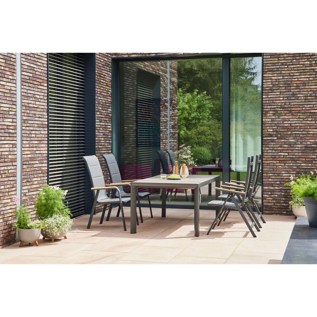 Gartenmöbel-Set mit Tisch und Stühlen auf einer Terrasse.