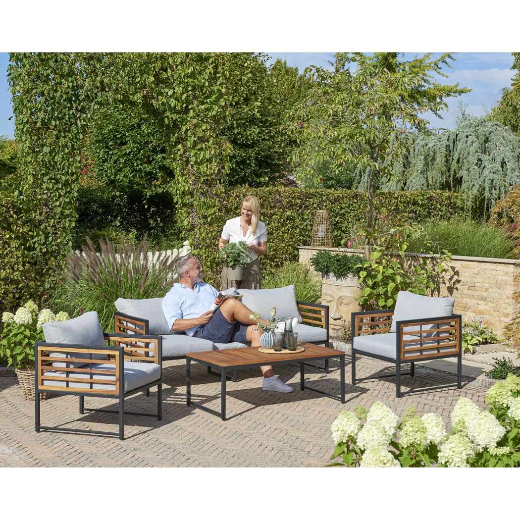 Zwei Personen entspannen auf Gartenmöbeln.