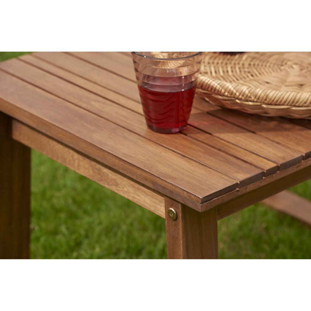 Holztisch mit Getränk und Korb