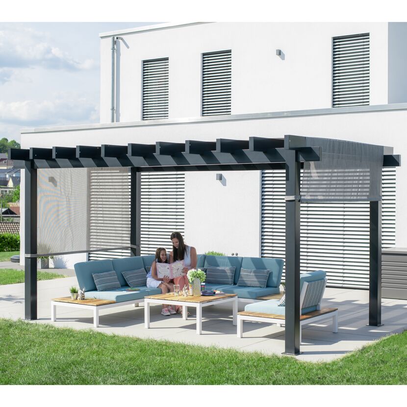 Zwei Personen sitzen auf einem Sofa unter einer Pergola.