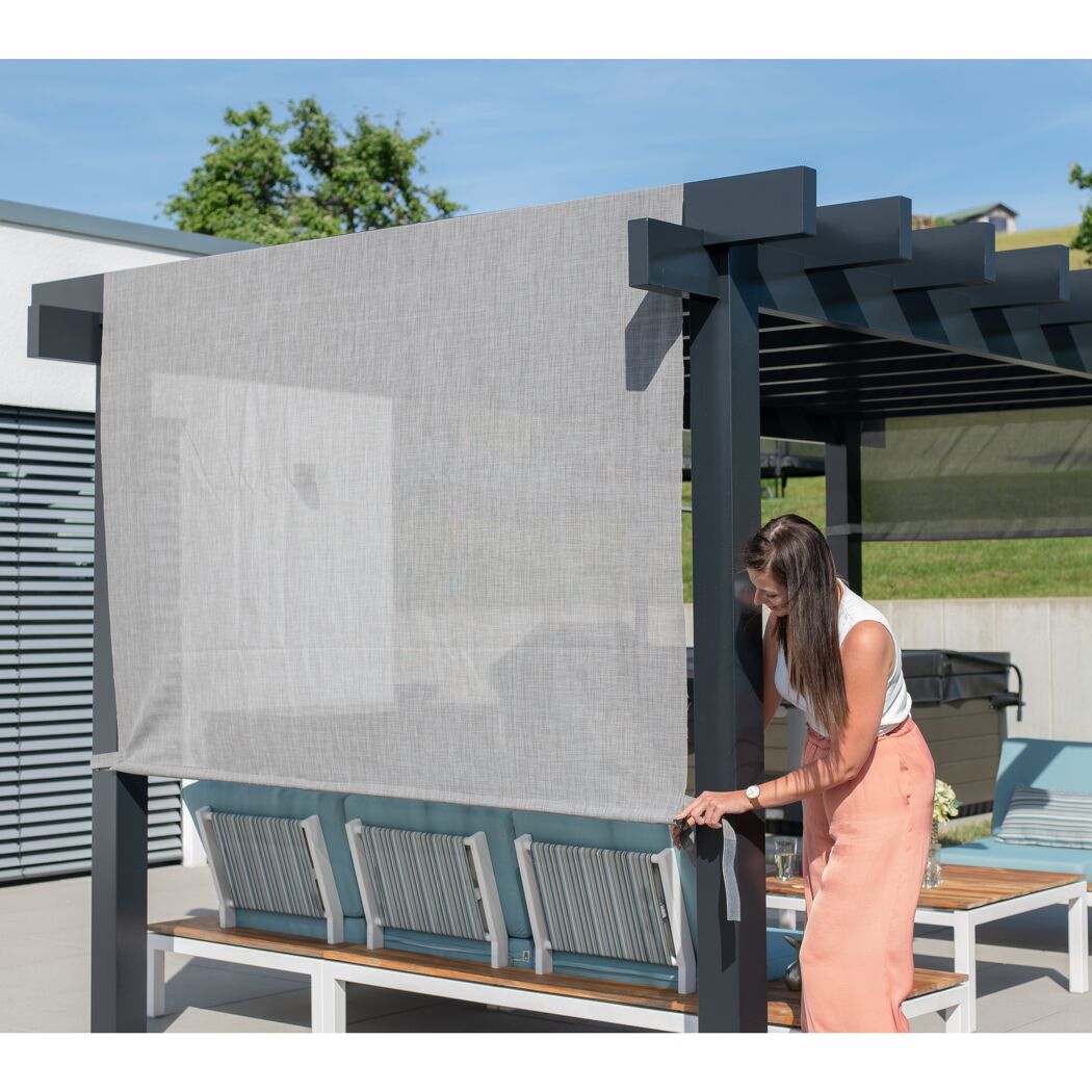 Person befestigt Sonnenschutz an Pergola