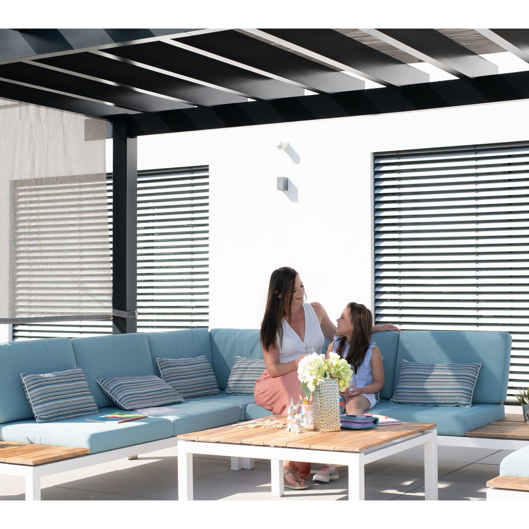 Zwei Personen sitzen auf einer Gartensofa unter einer Pergola.