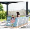 Person und Kind sitzen auf einer Gartenlounge unter einer Pergola.