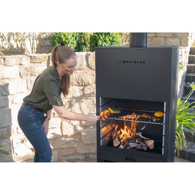 Person grillt mit dem Gartenkamin Westmann