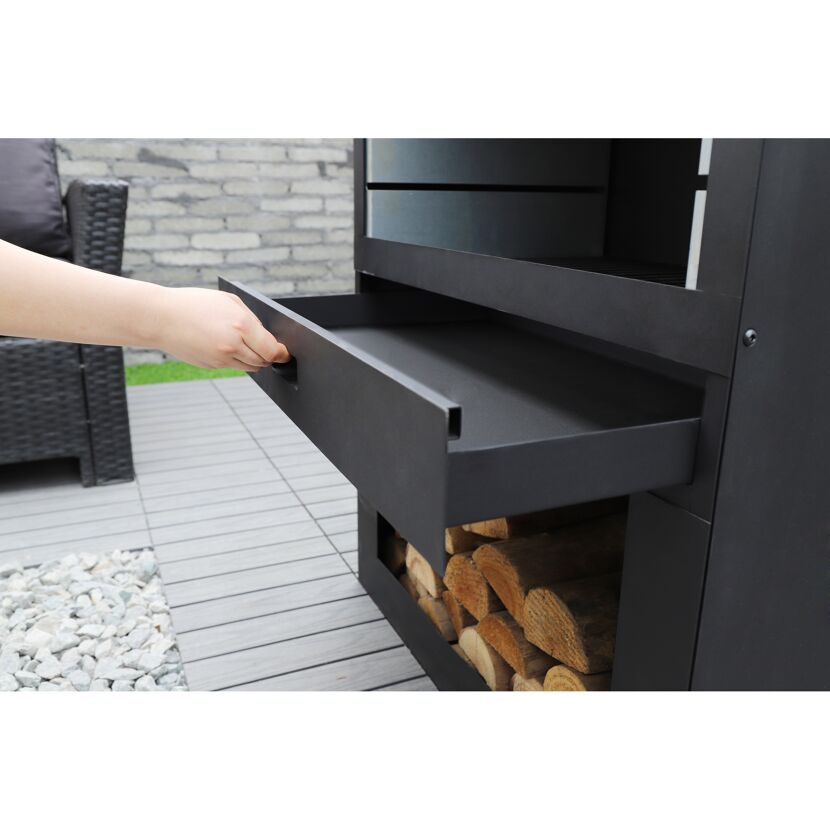 Person öffnet die Schublade eines schwarzen Gartenkamins