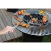 Person grillt Fleisch und Gemüse auf einem Grill.