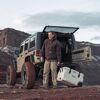 Person mit Kühlbox am Jeep