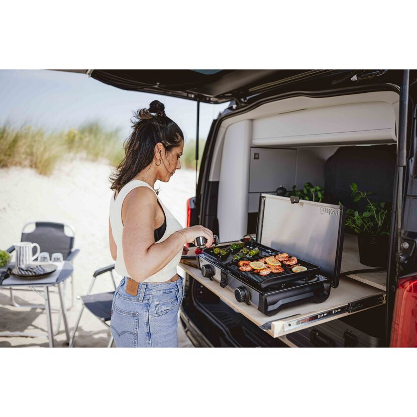 Person grillt auf einem Campingkocher