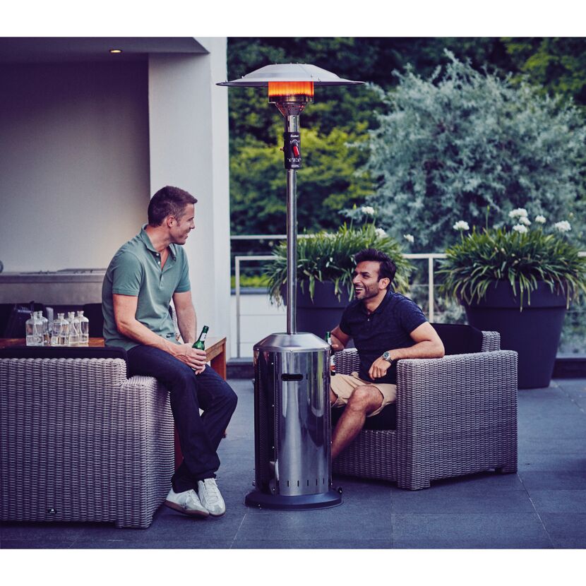 Zwei Personen sitzen auf einer Terrasse mit einem Terrassenheizer.