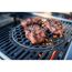 Drei Steaks brutzeln auf einem Grill.