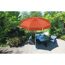 Orangener Sonnenschirm über Gartentisch