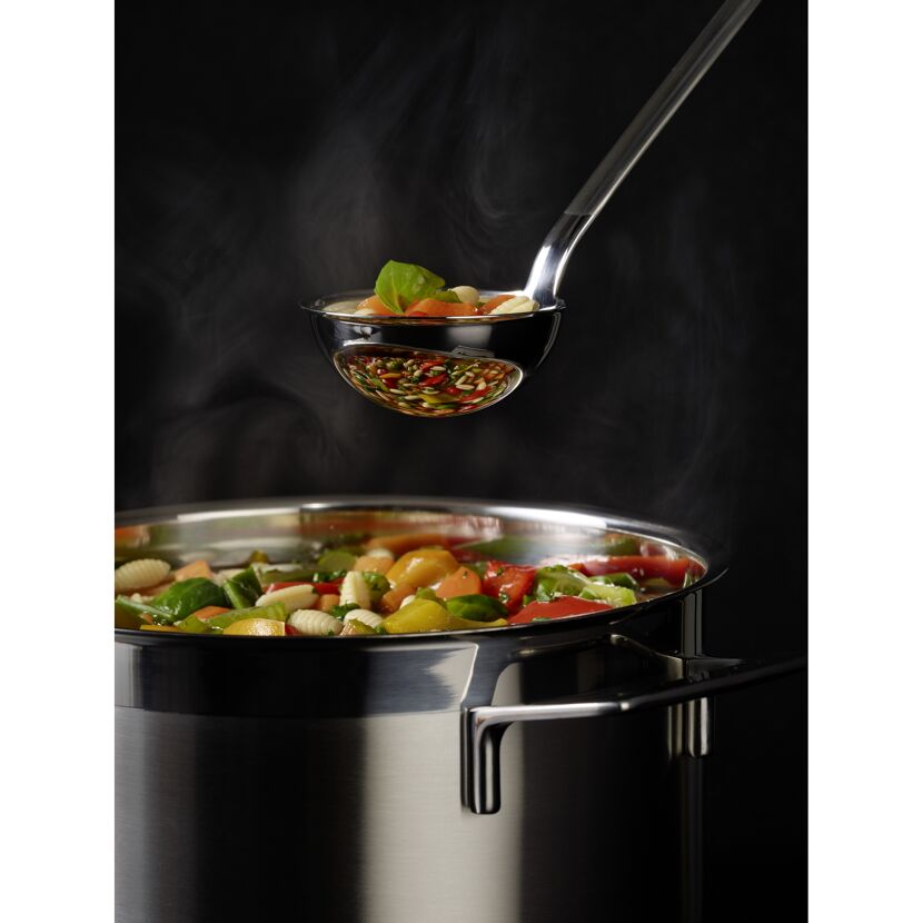 Dampfender Topf mit Gemüse und Schöpfkelle