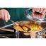 Person rührt mit einem Kochlöffel Suppe in einem Topf um
