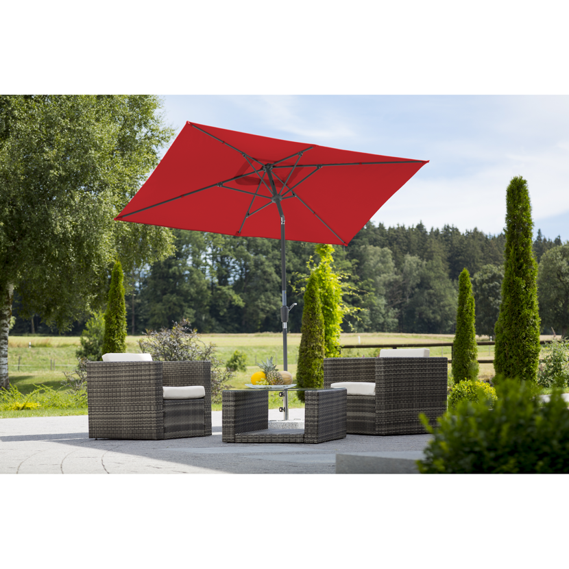 Roter Sonnenschirm über Sitzgruppe im Garten