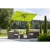 Grüner Sonnenschirm über Sitzgruppe im Garten
