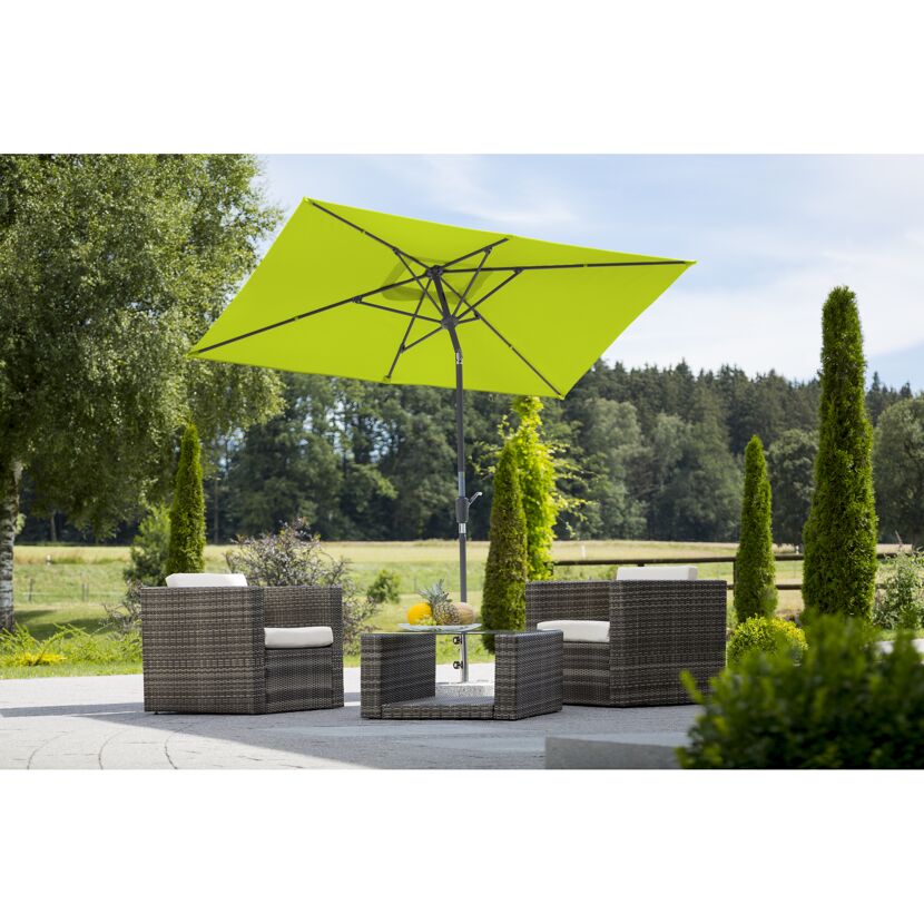 Grüner Sonnenschirm über Sitzgruppe im Garten