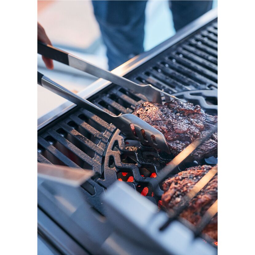 Steak wird mit einer Grillzange gewendet