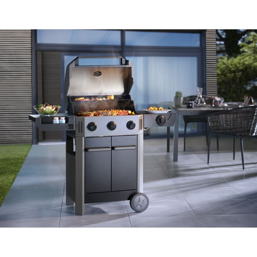 Gasgrill mit drei Brennern und aufgeklapptem Deckel, auf dem Essen zubereitet wird.