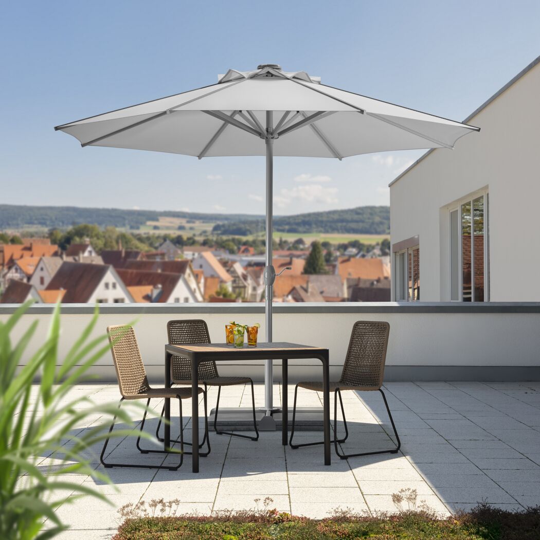 Tisch mit Stühlen und Sonnenschirm auf einer Dachterrasse