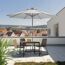 Tisch mit Stühlen und Sonnenschirm auf einer Dachterrasse