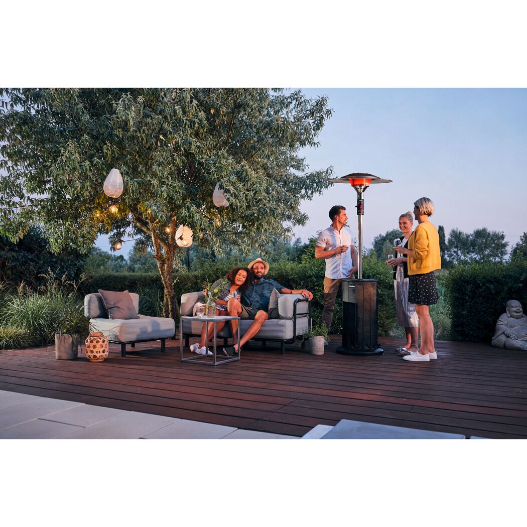 Personen sitzen auf Gartenmöbeln im Freien und unterhalten sich.