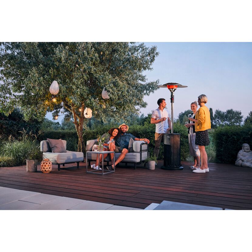 Personen sitzen auf Gartenmöbeln im Freien und unterhalten sich.