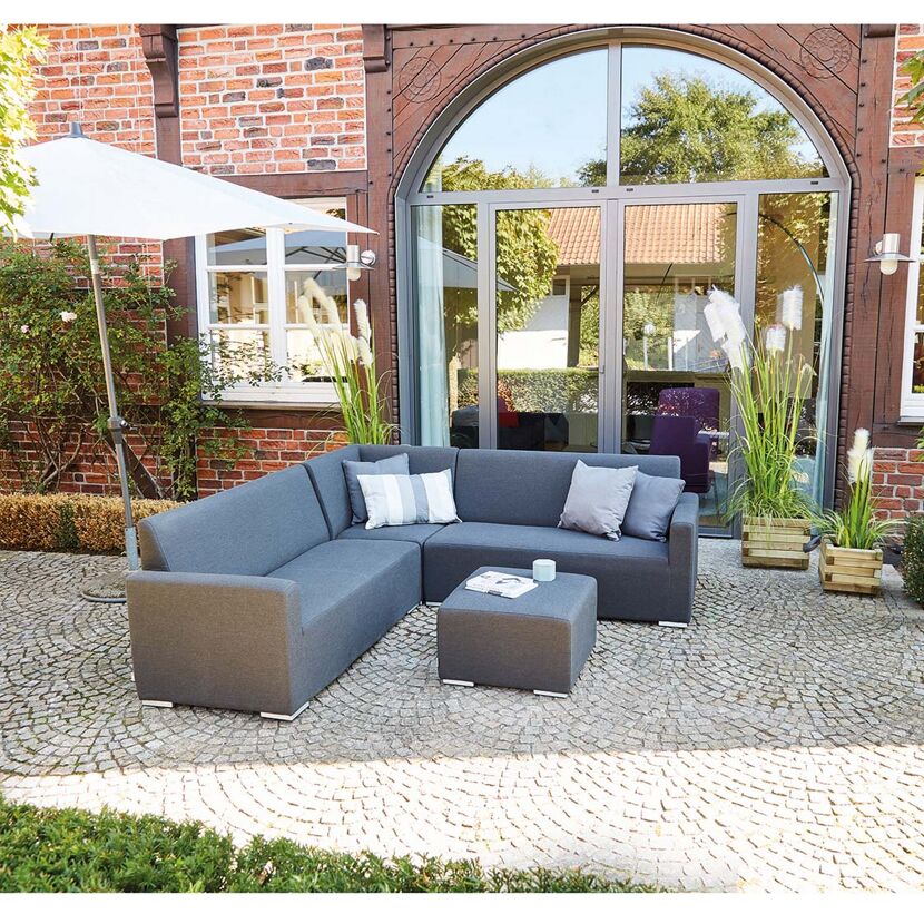Graue Gartenmöbel auf gepflastertem Boden