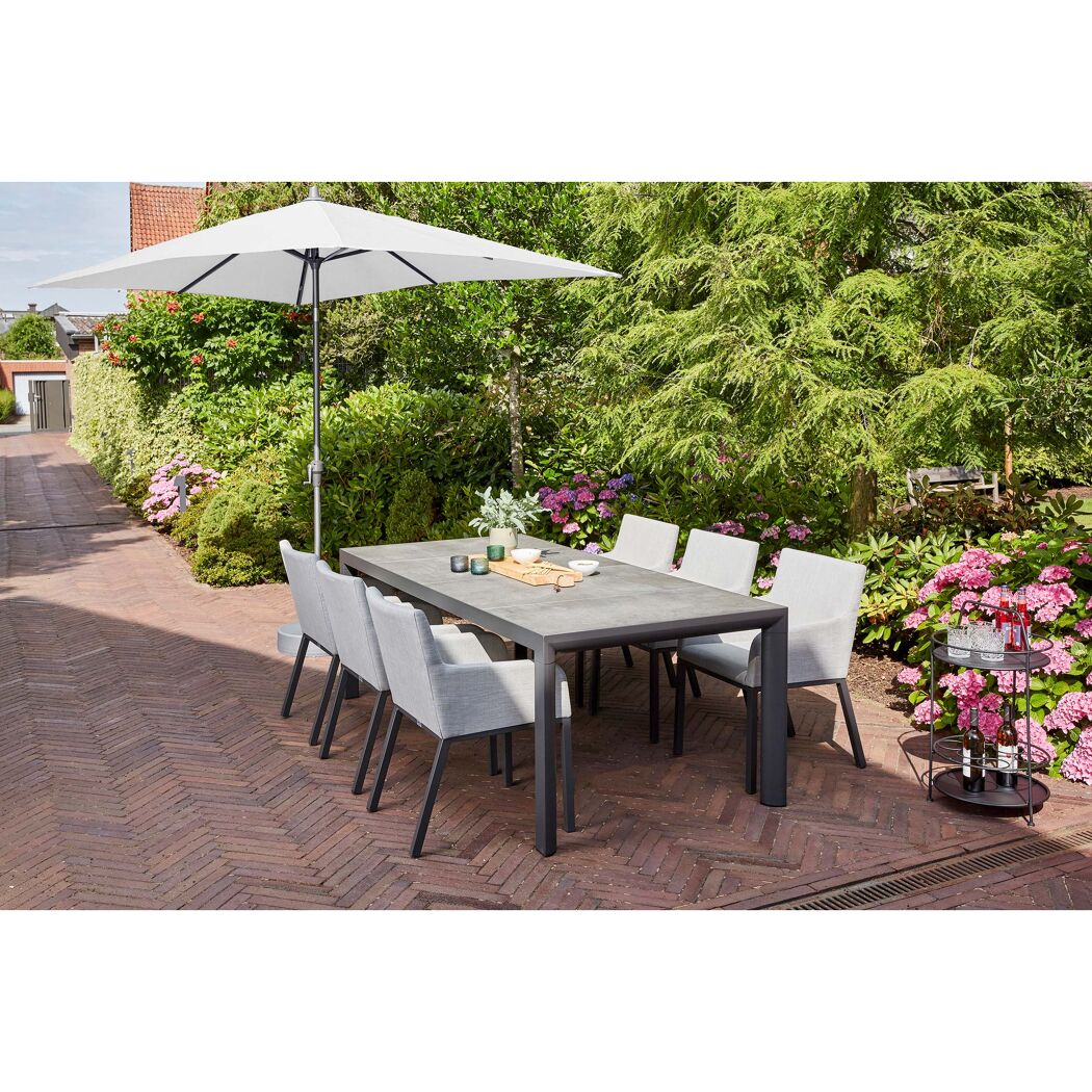 Gartenmöbel-Set mit Sonnenschirm auf gepflasterter Terrasse