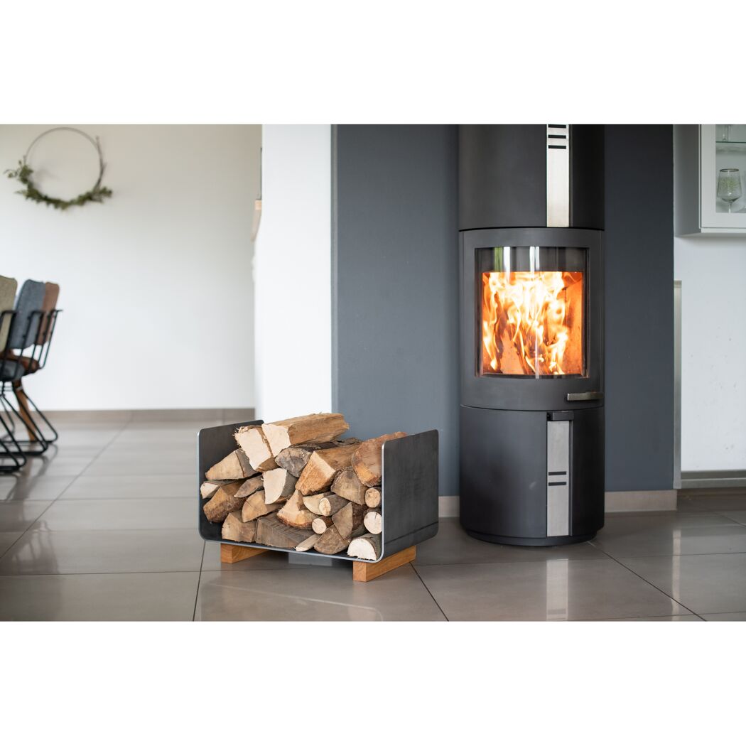Kamin mit brennendem Feuer und Holzkorb