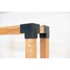 Holzbalken mit schwarzen Metallwinkeln verbunden